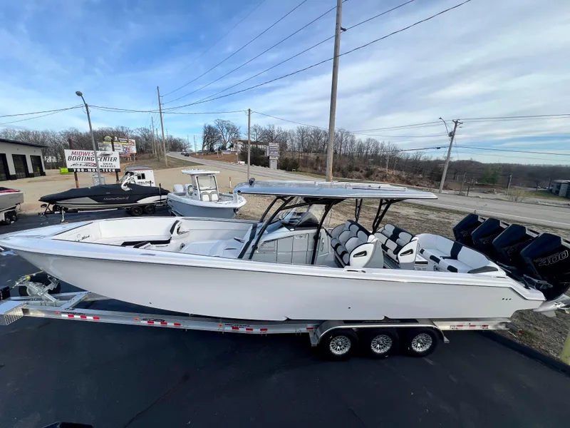 Slide: The Image of 2025 Nor-Tech 390 Sport Center Console boat on trailer, featuring sleek design and powerful engines. - 2