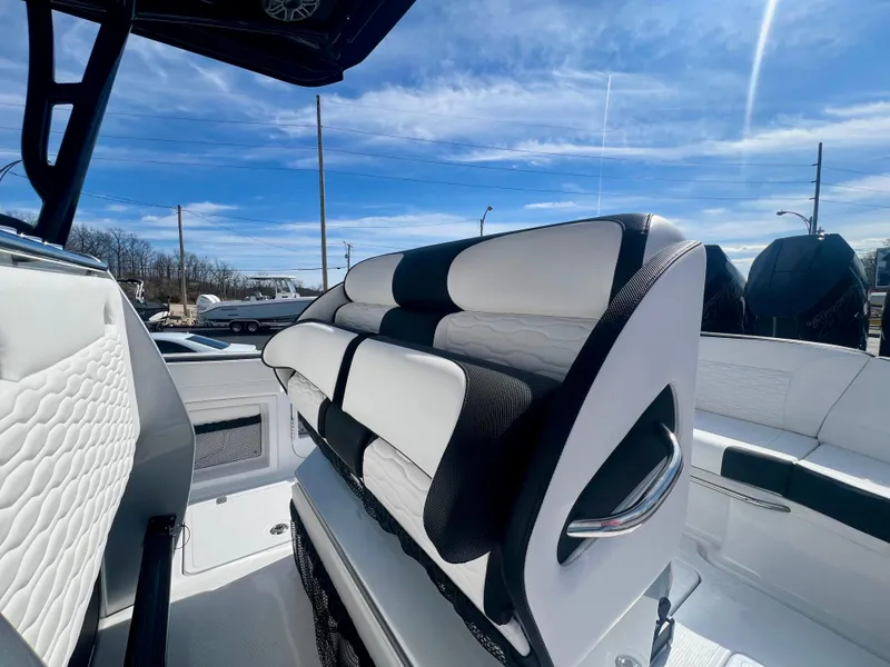 Slide: The Image of 2025 Nor-Tech 390 Sport Center Console with sleek seating and modern design under a clear sky. - 20