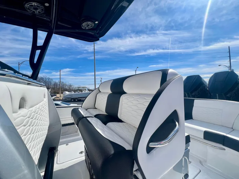 Slide: The Image of 2025 Nor-Tech 390 Sport Center Console with sleek seating and modern design under a clear sky. - 21