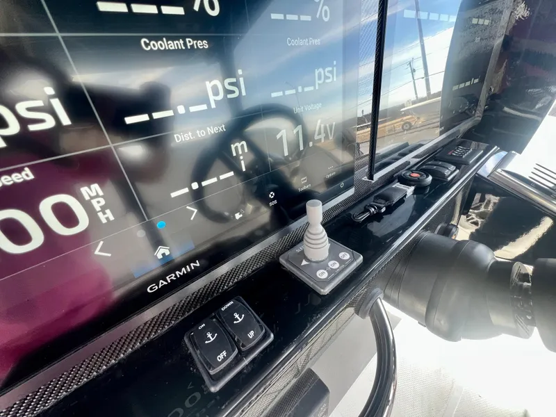 Slide: The Image of 2025 Nor-Tech 390 Sport Center Console dashboard with Garmin display and controls. - 32