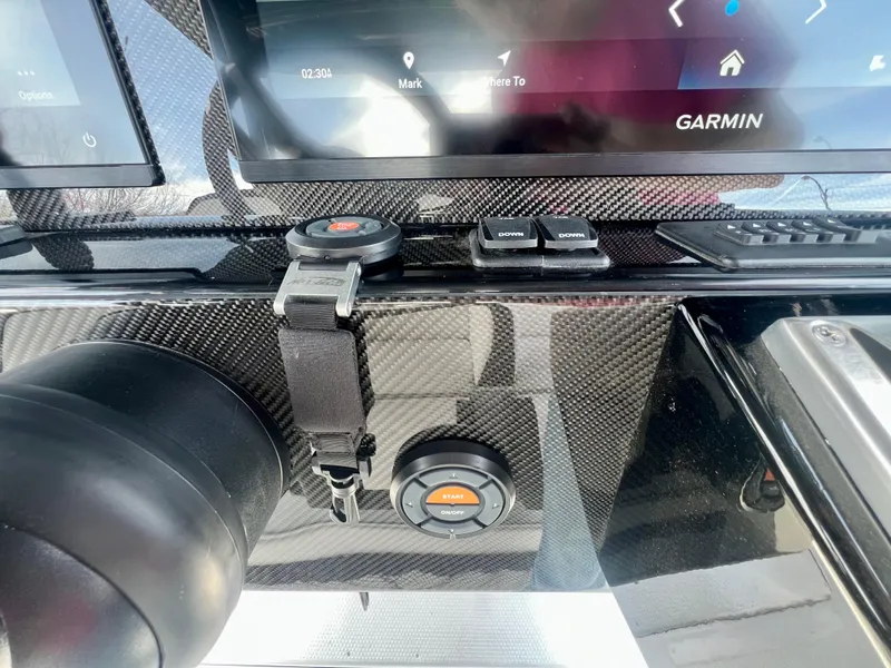 Slide: The Image of 2025 Nor-Tech 390 Sport Center Console dashboard with Garmin display and controls. - 35