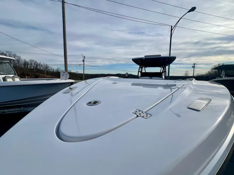 Slide: The Image of 2025 Nor-Tech 390 Sport Center Console boat, sleek design, docked under cloudy sky. - 4