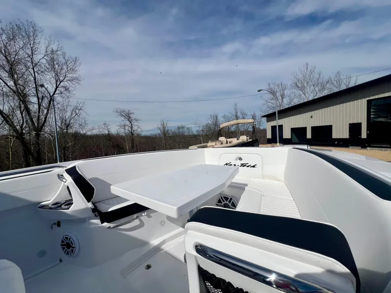 Slide: The Image of 2025 Nor-Tech 390 Sport Center Console boat with seating and table, outdoors. - 41