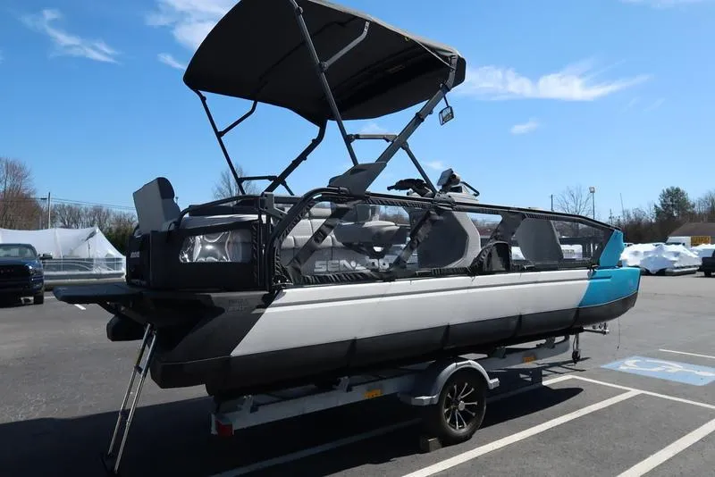 Slide: The Image of 2023 Sea-Doo Switch® Sport 21-230 hp Galvanized pontoon boat on trailer, parked outdoors. - 6