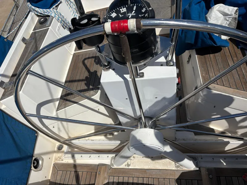 Slide: The Image of Steering wheel of 1994 Nautor Swan 46 MK II yacht with compass and wooden deck. - 16