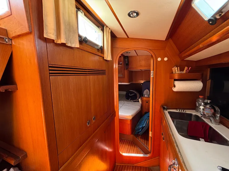 Slide: The Image of Interior of 1994 Nautor Swan 46 MK II yacht, featuring wood paneling and compact kitchen area. - 36