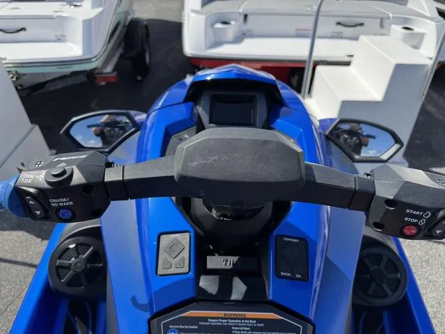 Slide: The Image of 2023 Yamaha WaveRunner GP1800R dashboard and controls, blue watercraft, parked near boats. - 9