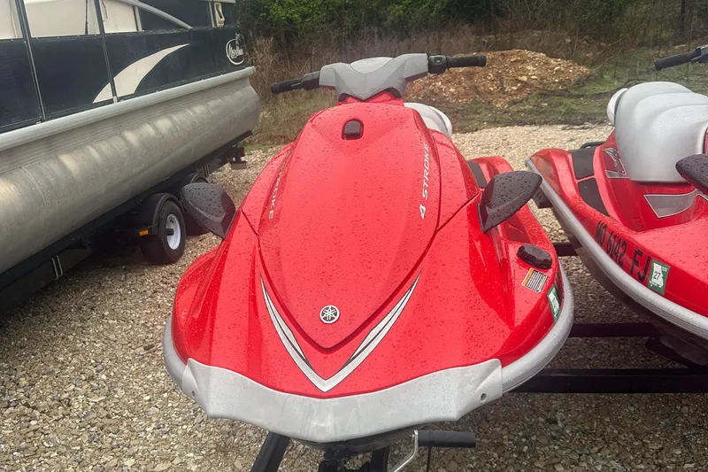 Slide: The Image of 2006 Yamaha WaveRunner VX 110 Deluxe in red, parked on gravel near a trailer. - 6