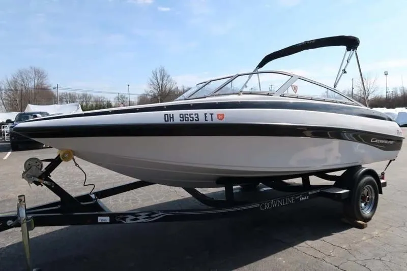 Slide: The Image of 2011 Crownline 18 SS boat on trailer, parked outdoors under clear sky. - 2