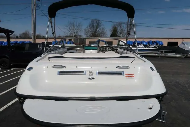 Slide: The Image of 2011 Crownline 18 SS boat, rear view, parked outdoors under clear sky. - 3