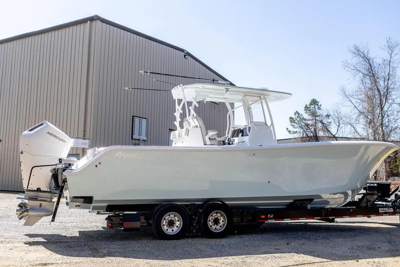 Slide: The Image of 2023 Front Runner 33 Center Console boat on trailer near a large building. - 0
