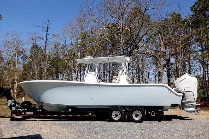 Slide: The Image of 2023 Front Runner 33 Center Console boat on trailer, parked outdoors. - 1