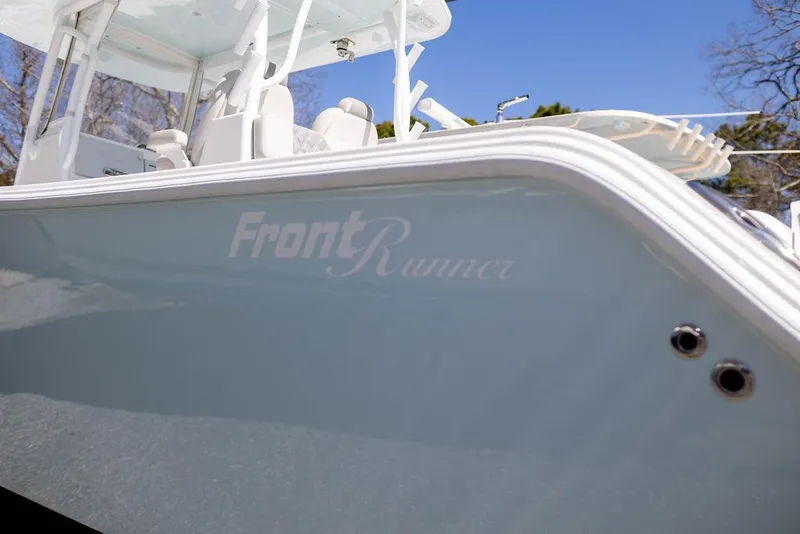 Slide: The Image of 2023 Front Runner 33 Center Console boat, side view with logo, under clear blue sky. - 10