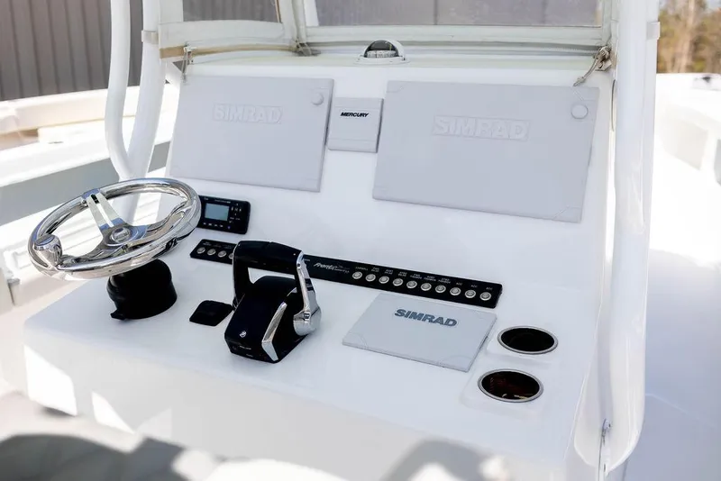 Slide: The Image of 2023 Front Runner 33 Center Console boat dashboard with steering wheel and Simrad electronics. - 16