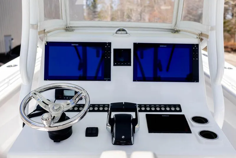 Slide: The Image of 2023 Front Runner 33 Center Console boat dashboard with dual screens and steering wheel. - 19