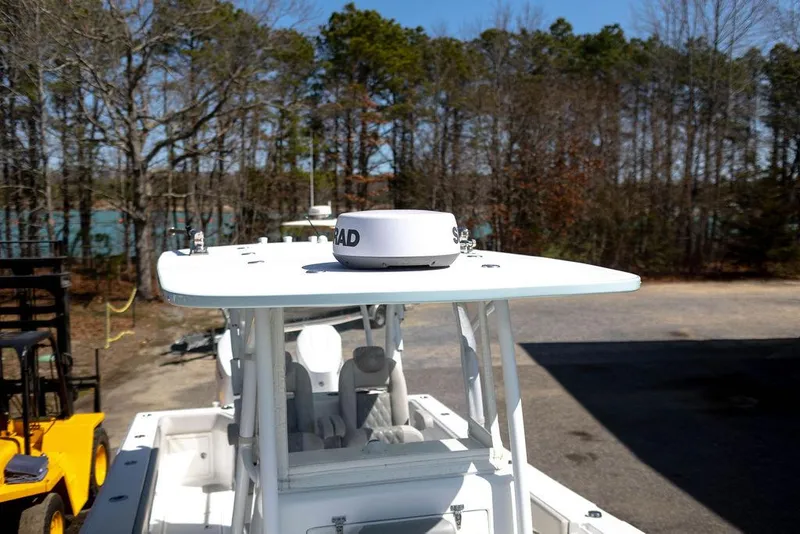 Slide: The Image of 2023 Front Runner 33 Center Console boat with radar, parked outdoors near trees. - 35