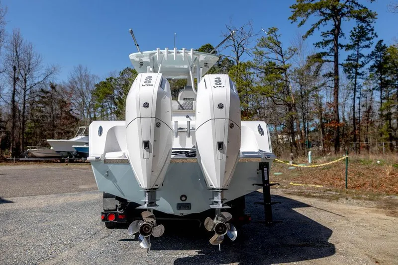 Slide: The Image of 2023 Front Runner 33 Center Console boat with dual outboard engines, parked outdoors. - 6