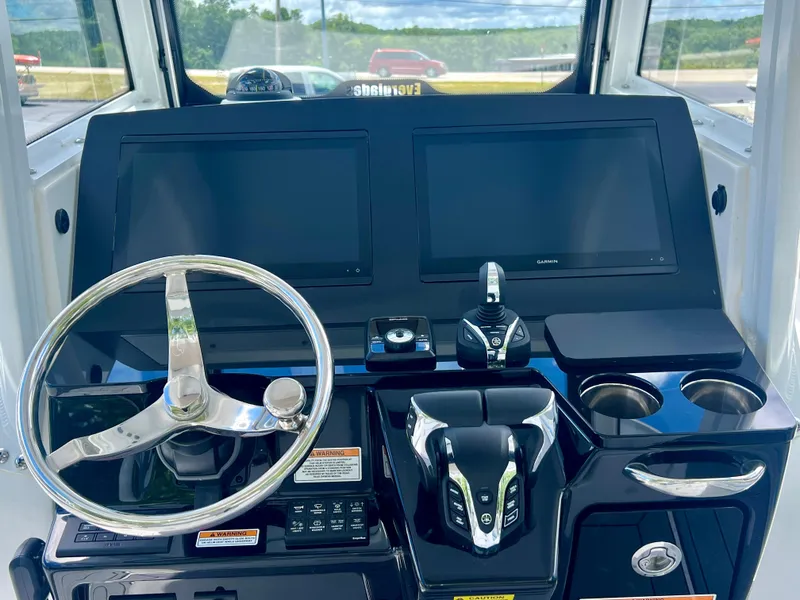 Slide: The Image of 2024 Everglades 285 Center Console boat dashboard with dual screens and steering wheel. - 15