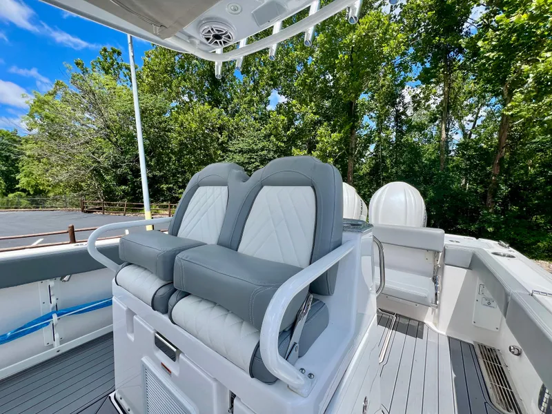 Slide: The Image of 2024 Everglades 285 Center Console boat with dual seats and lush green backdrop. - 19
