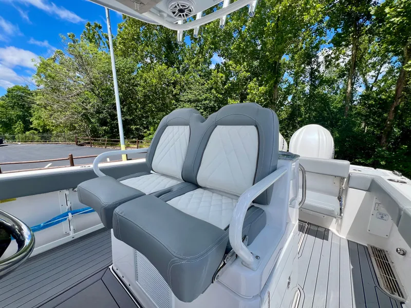 Slide: The Image of 2024 Everglades 285 Center Console boat with dual gray and white seats, outdoor setting. - 20