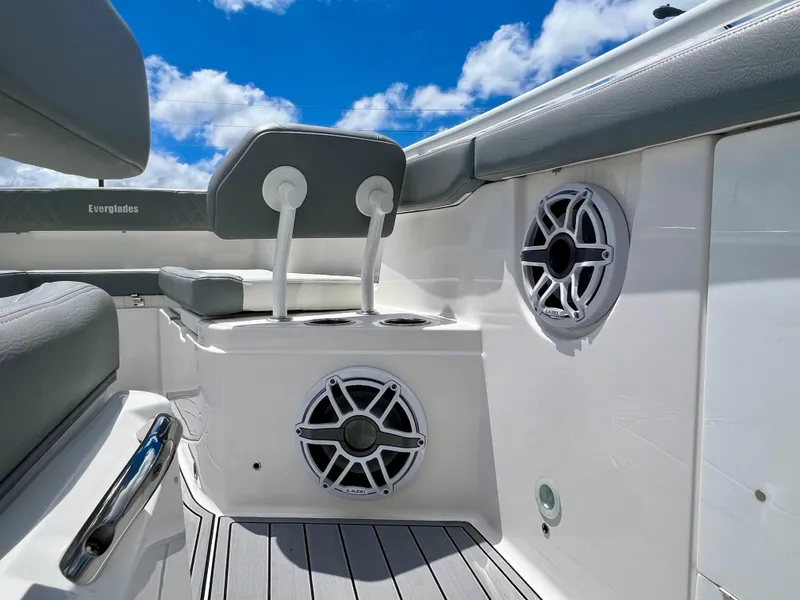 Slide: The Image of 2024 Everglades 285 Center Console boat interior with speakers and seating under a blue sky. - 31