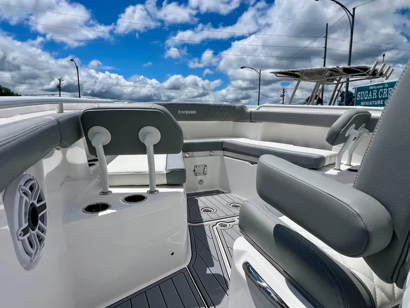 Slide: The Image of 2024 Everglades 285 Center Console boat interior with seating and cup holders under a blue sky. - 32