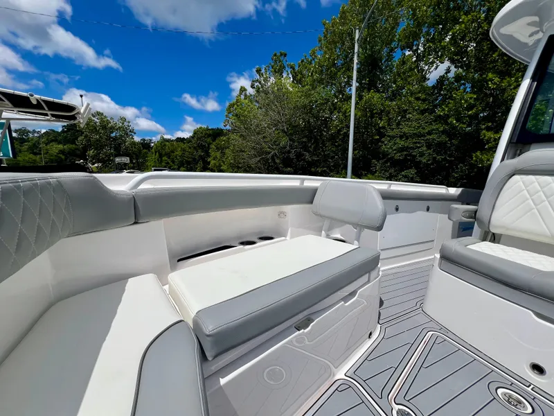 Slide: The Image of 2024 Everglades 285 Center Console boat interior with seating, under a clear blue sky. - 36