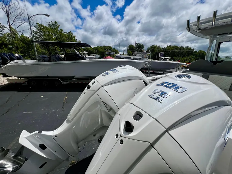 Slide: The Image of 2024 Everglades 285 Center Console with twin 300 V6 outboard engines, parked outdoors. - 43