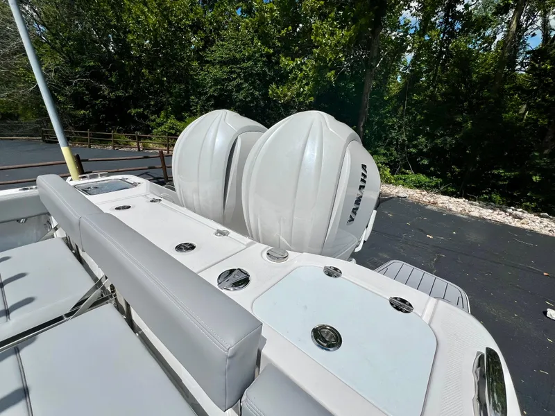 Slide: The Image of 2024 Everglades 285 Center Console boat with dual outboard engines, surrounded by lush greenery. - 44