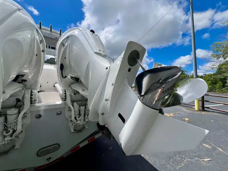 Slide: The Image of 2024 Everglades 285 Center Console boat with dual outboard engines under a clear blue sky. - 5