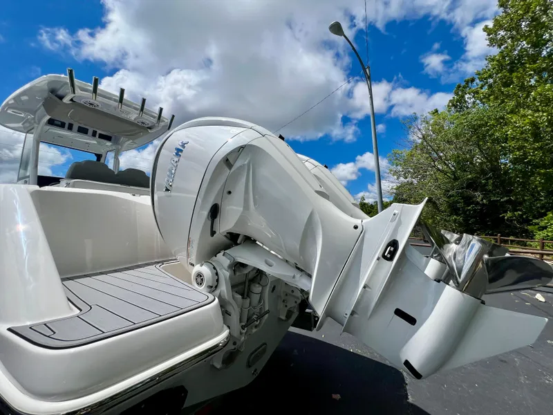 Slide: The Image of 2024 Everglades 285 Center Console boat with powerful outboard motor, under a partly cloudy sky. - 6