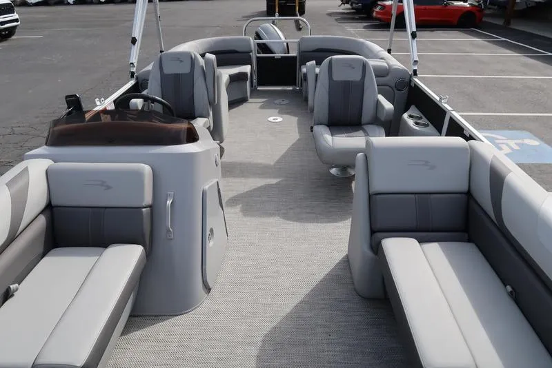 Slide: The Image of 2024 Bennington 22 SXSR pontoon boat interior with gray seating and helm. - 11
