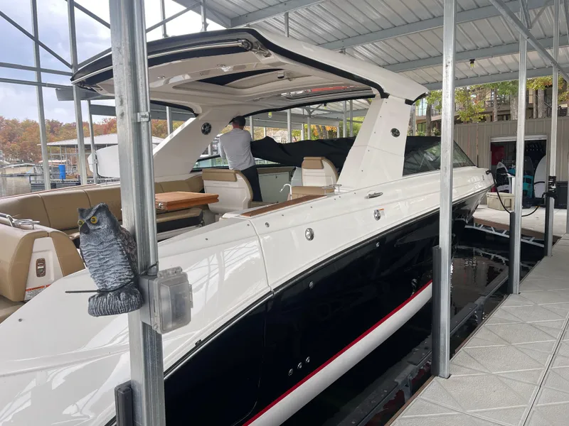Slide: The Image of 2022 Sea Ray 400 SLX luxury boat docked under a covered marina. - 11
