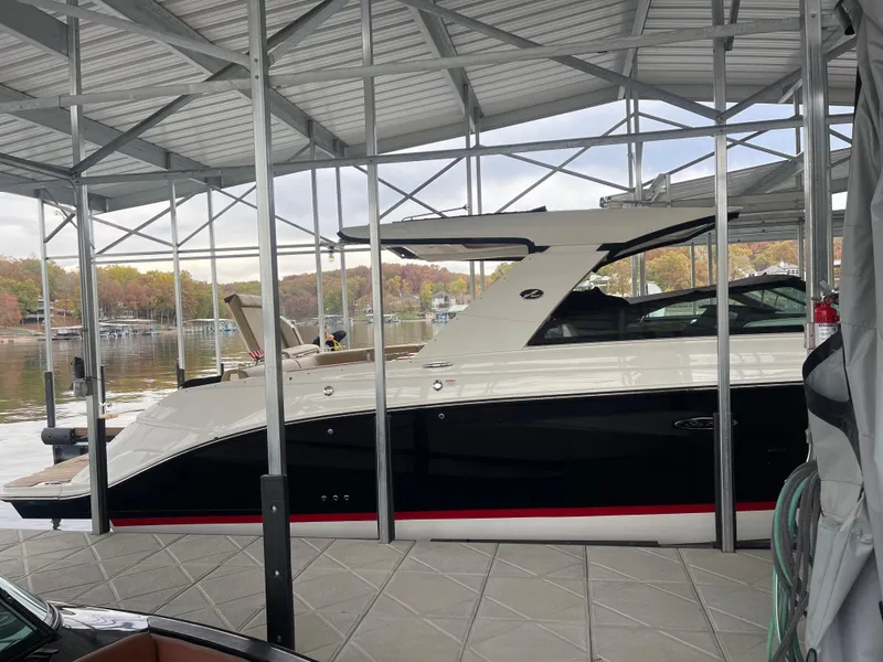 Slide: The Image of 2022 Sea Ray 400 SLX boat docked under a metal canopy. - 12