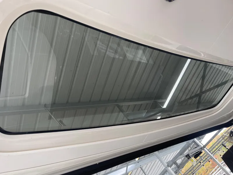 Slide: The Image of 2022 Sea Ray 400 SLX boat window under a metal roof. - 18