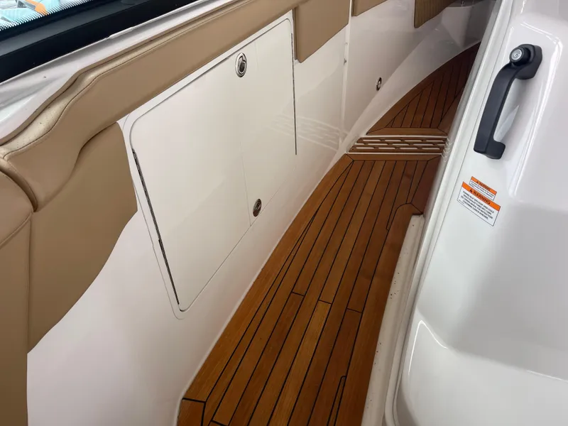 Slide: The Image of 2022 Sea Ray 400 SLX boat interior with teak flooring and beige accents. - 19