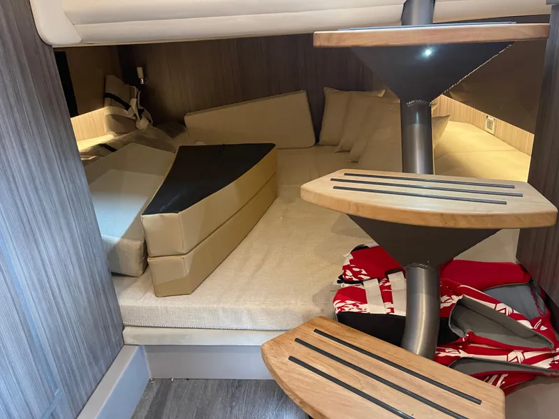 Slide: The Image of 2022 Sea Ray 400 SLX cabin interior with modern staircase and cozy seating area. - 26