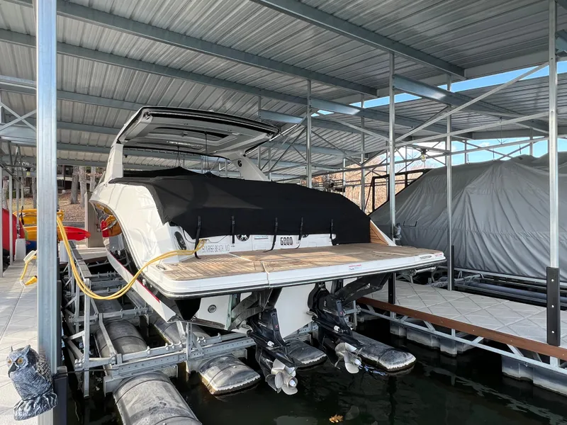 Slide: The Image of 2022 Sea Ray 400 SLX boat docked under a covered marina. - 30