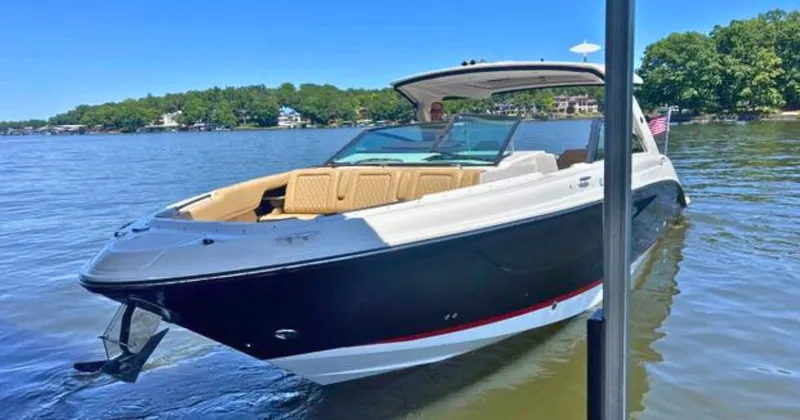 Slide: The Image of 2022 Sea Ray 400 SLX boat on a calm lake with lush green shoreline. - 5