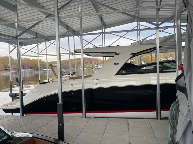 Slide: The Image of 2022 Sea Ray 400 SLX boat docked under a metal canopy. - 7