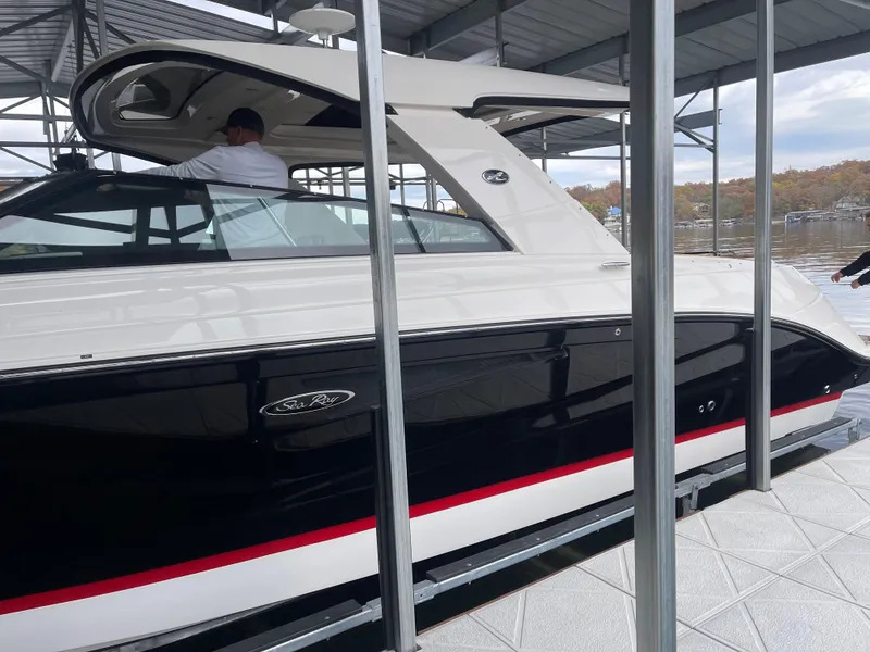Slide: The Image of 2022 Sea Ray 400 SLX boat docked under a covered marina. - 8