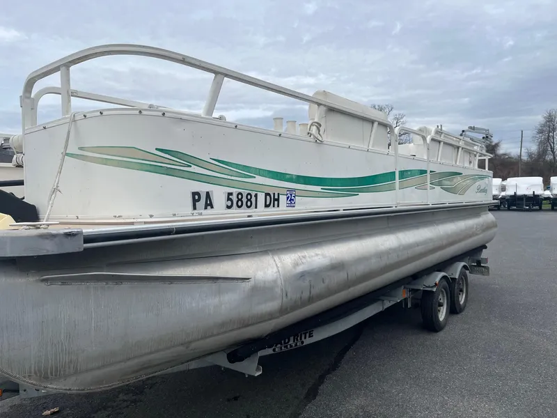 Slide: The Image of 2009 Bentley Pontoons 244 4-point boat on trailer, side view, cloudy sky background. - 4
