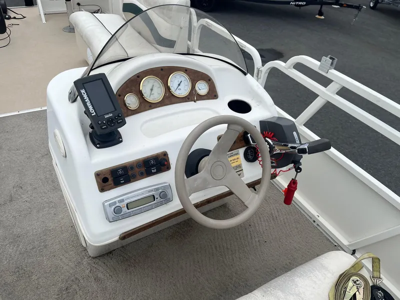 Slide: The Image of 2009 Bentley Pontoons 244 4-point helm with steering wheel, gauges, and navigation system. - 6