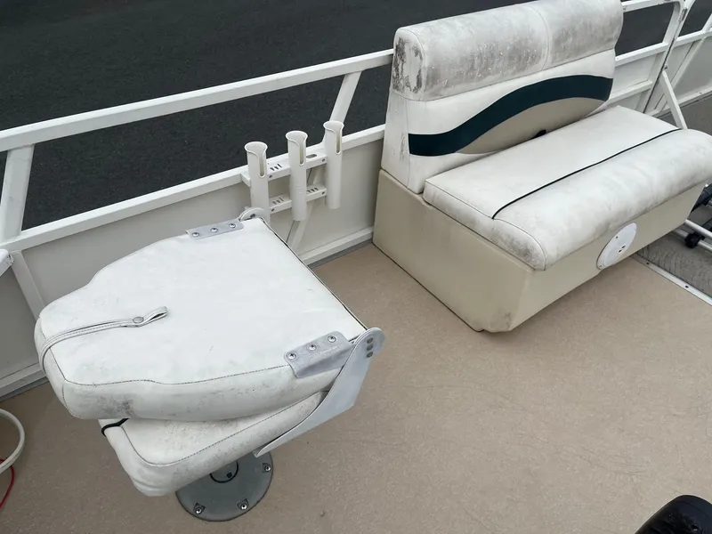 Slide: The Image of 2009 Bentley Pontoons 244 4-point boat seating with white upholstery and rod holders. - 7