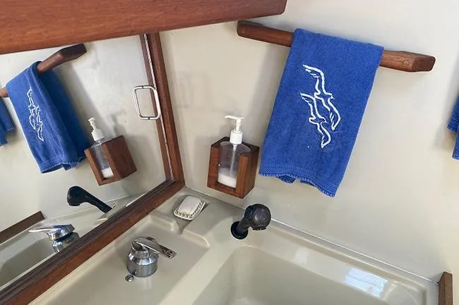 Slide: The Image of 1981 C&C Landfall 35 yacht bathroom with blue towel and soap dispenser. - 17