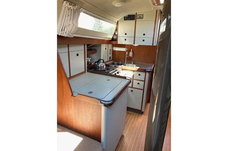 Slide: The Image of 1981 C&C Landfall 35 yacht interior kitchen with wood cabinetry and modern appliances. - 27