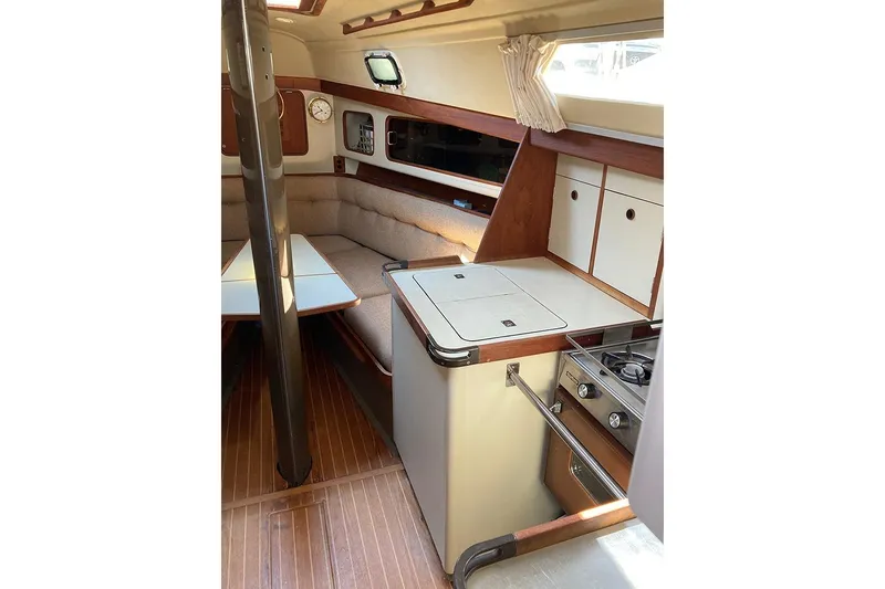 Slide: The Image of 1981 C&C Landfall 35 yacht interior with cozy seating, compact kitchen, and wooden accents. - 31