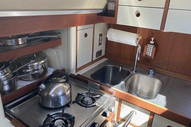 Slide: The Image of 1981 C&C Landfall 35 yacht kitchen with stove, sink, and storage cabinets. - 8
