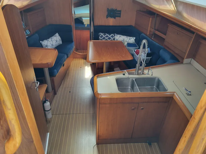 Slide: The Image of Interior of 2001 Jeanneau Sun Odyssey 37 sailboat with wood finish and blue seating. - 19