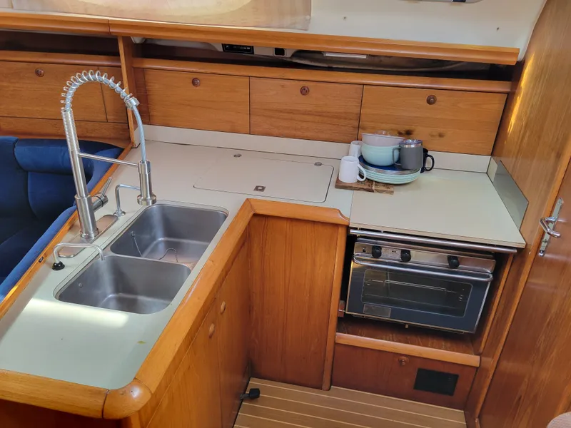 Slide: The Image of Jeanneau Sun Odyssey 37 yacht kitchen with sink, stove, and wooden cabinetry, 2001 model. - 21